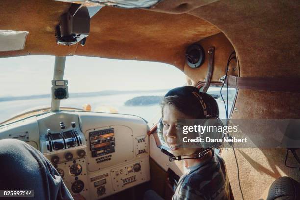 boy riding in cockpit of small plane - hidroavión fotografías e imágenes de stock