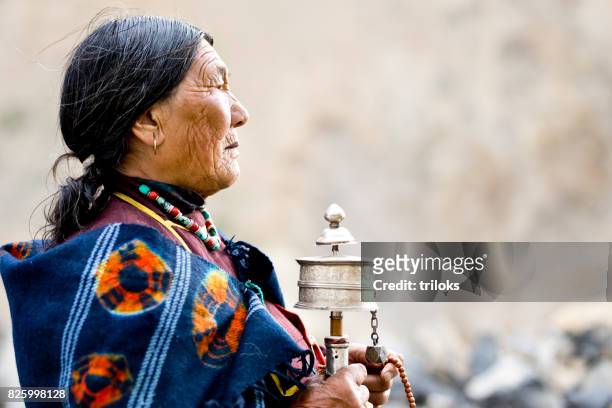 祈りの輪とビーズを保持している古い女性 - tibetan culture ストックフォトと画像