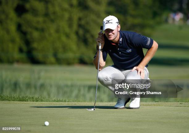Chris Wood of England lines up a putt on the fifth green during thei first round of the World Golf Championships - Bridgestone Invitational at...