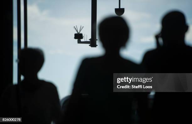 Passersby walk under a surveillance camera which is part of facial recognition technology test at Berlin Suedkreuz station on August 3, 2017 in...