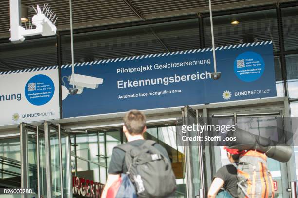 Passersby walk under a surveillance camera which is part of facial recognition technology test at Berlin Suedkreuz station on August 3, 2017 in...