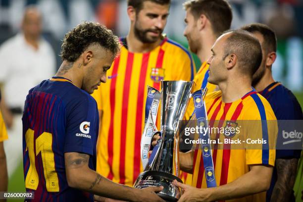 Neymar of Barcelona holds the trophy with Andres Iniesta of Barcelona after the International Champions Cup El Clásico match between FC Barcelona and...