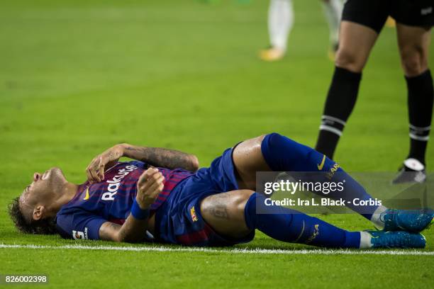 Neymar of Barcelona lays on the ground from another hit during the International Champions Cup El Clásico match between FC Barcelona and Real Madrid...