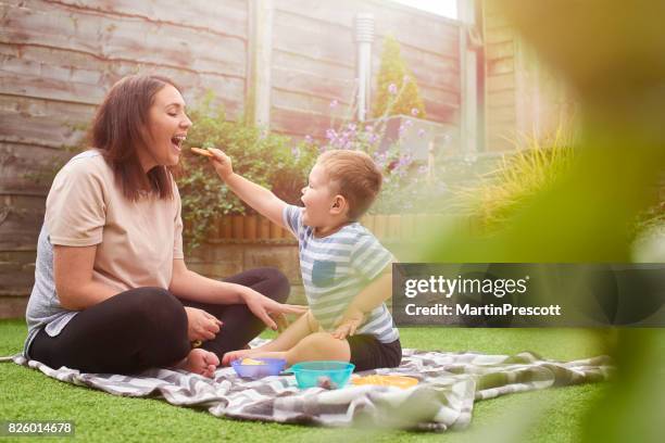 plezier voederen mummie - mother and child snacking stockfoto's en -beelden