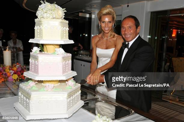 Anna Anka and Paul Anka pose as they're cutting the wedding cake during their wedding on the yacht M.Y Siran on July 26, 2008 in Porto Cervo,...