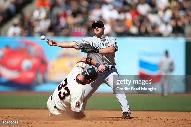 Dan Uggla of the Florida Marlins throws as Aaron Rowand of the San Francisco Giants slides into second base during the game at AT&T Park in San...