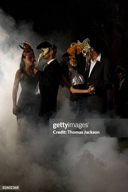 carneval mask party outdoors at night - venetiaans masker vasthouden stockfoto's en -beelden