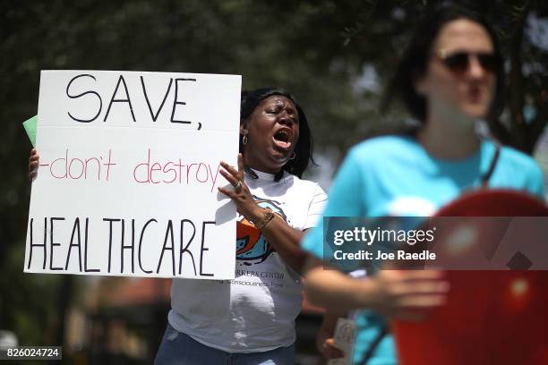 Trenise Bryant joins others for a protest in front of the office of Rep. Carlos Curbelo on August 3, 2017 in Miami, Florida. The protesters are...