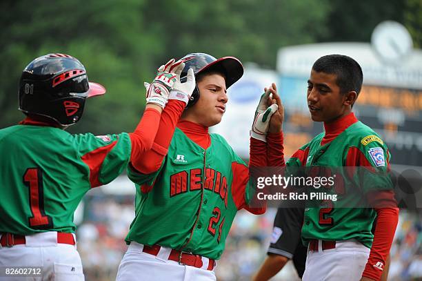 Jesus Sauceda of the Matamoros Team is greeted by Octavio Salinas and Tomas Castillo after hitting a home run during the World Series Championship...