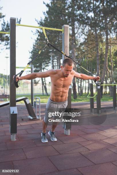 man doen gymnastiek oefeningen met bungee-koord buiten - bungee cord stockfoto's en -beelden