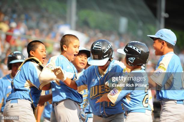 Tanner Tokunaga of the Waipio Little League team is greeted by teammates after hitting a home run during the World Series Championship game against...