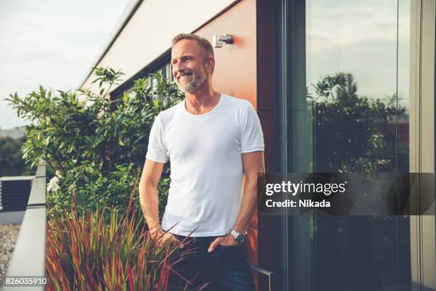 gut aussehender mann auf einem balkon stehend - berlin sommer stock-fotos und bilder