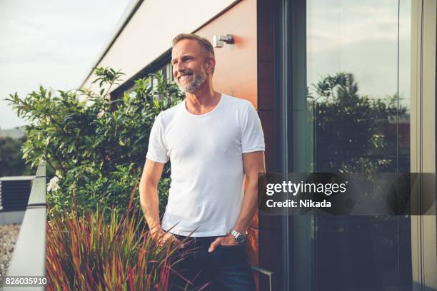 handsome man standing on a balcony - older men stock pictures, royalty-free photos & images