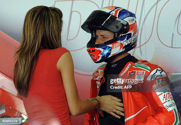 Adriana Stoner adjusts the shirt of her houseband, Australian world champion MotoGP racer Casey Stoner before the third free practice session at the...