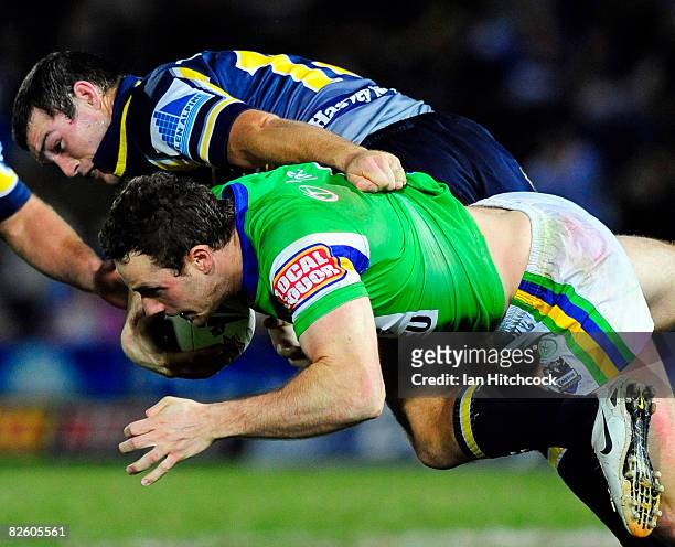 Colin Best of the Raiders is tackled by Ben Harris of the Cowboys during the round 25 NRL match between the North Queensland Cowboys and the Canberra...