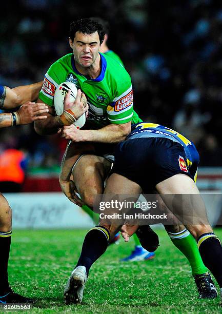 Dane Tilse of the Raiders is wrapped up by Ben Harris of the Cowboys during the round 25 NRL match between the North Queensland Cowboys and the...