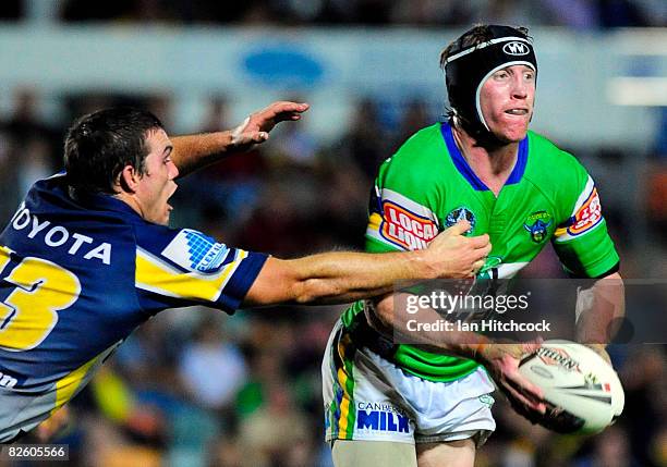 Alan Tongue of the Raiders looks to get a pass away despite the defence of Ben Harris of the Cowboys during the round 25 NRL match between the North...