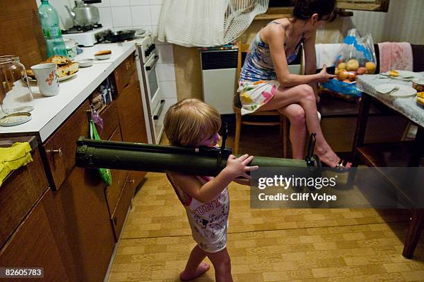 Two year old Georgian toddler plays with an empty Russian made RPG-26 rocket launcher that was found by a villager abandoned in the conflict zone on...