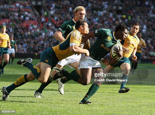 Jongi Nokwe of South Africa dives over to score his fourth try of the match despite being tackled by Timana Tahu of Australia during the 2008 Tri...
