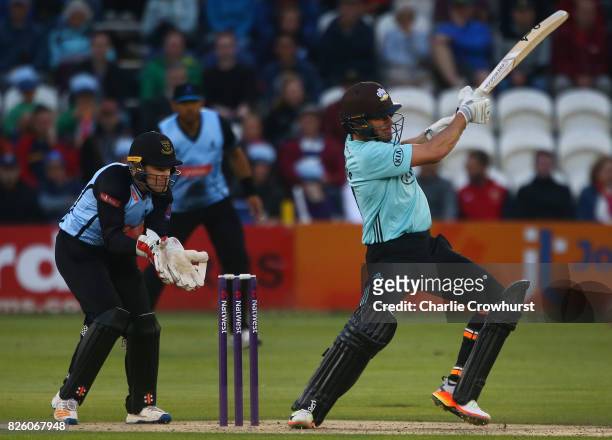 Moises Henriques of Surrey hits out while Ben Brown of Sussex tends the wicket during the NatWest T20 Blast match between Sussex Sharks and Surrey at...