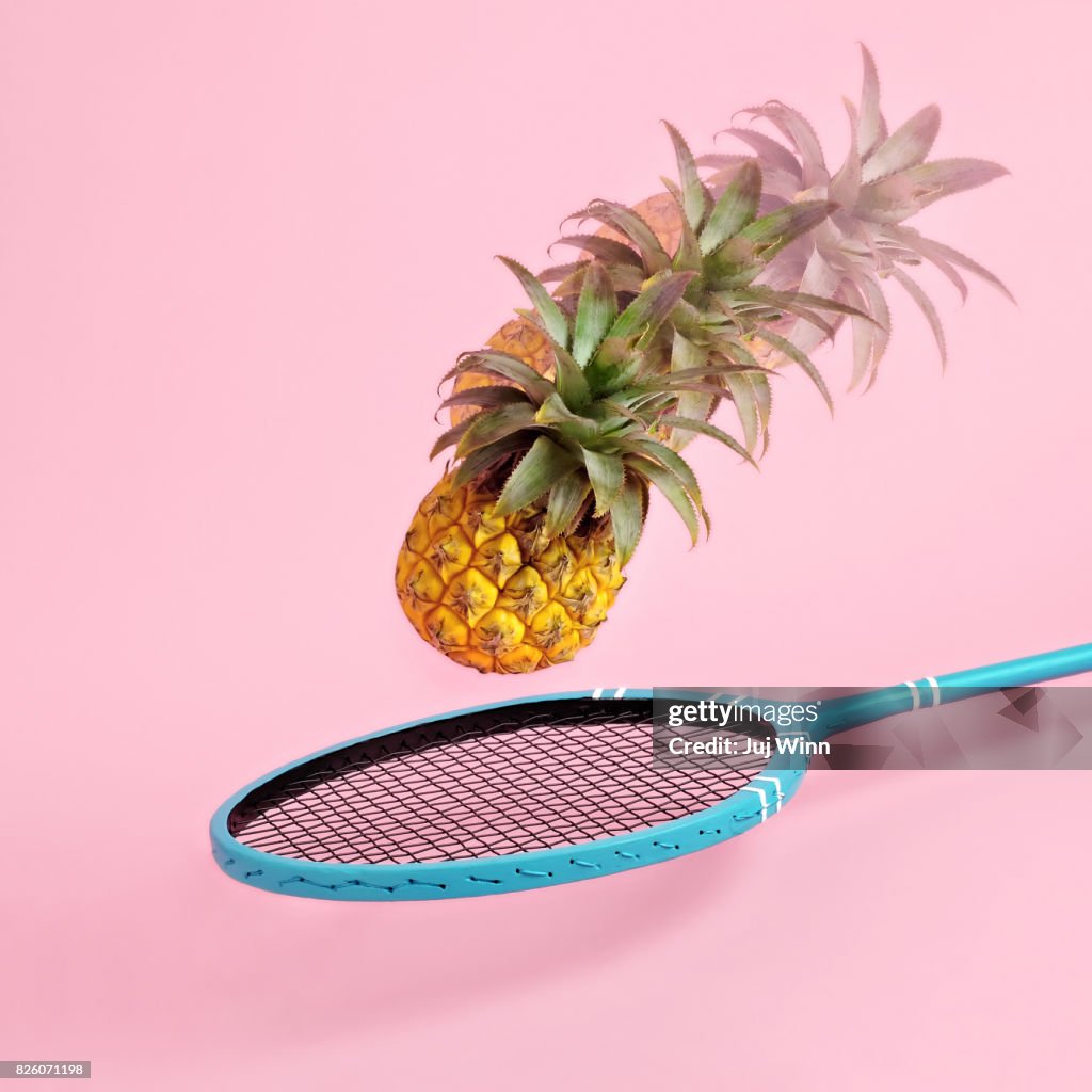 Pineapple flying toward badminton racket