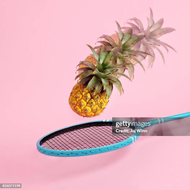 pineapple flying toward badminton racket - badminton sport stockfoto's en -beelden