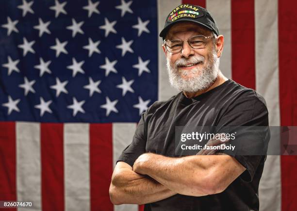 authentic vietnam veteran with american flag - veterans day stock pictures, royalty-free photos & images