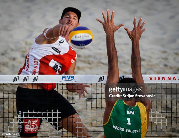 Martin Ermacora of Austria spikes the ball against Pedro Solberg of Brazil during the Men's Main draw elimination match between Austria and Brazil on...