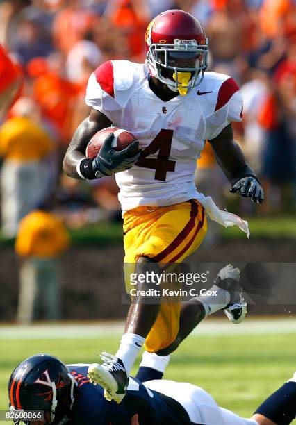 Running back Joe McKnight of the University of Southern California Trojans rushes upfield past defensive end Alex Field of the Virginia Cavaliers...