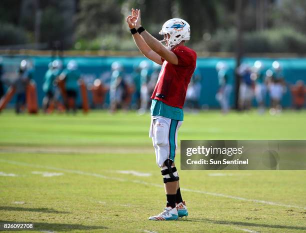 Miami Dolphins quarterback Ryan Tannehill signals OK to a teammate during Dolphins training camp on Thursday, Aug. 3, 2017 at Doctors Hospital...