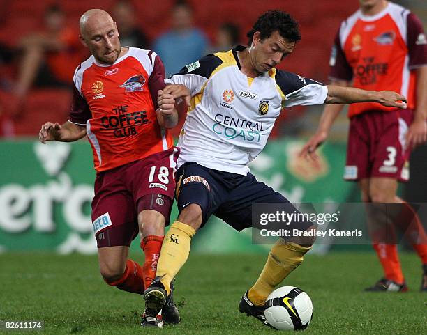 John Hutchinson of the Mariners takes on the defence of Danny Tiatto of the Roar during the round three A-League match between the Queensland Roar...