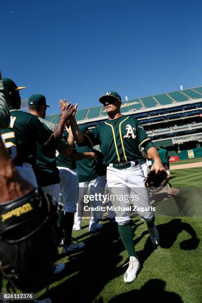 Jaycob Brugman of the Oakland Athletics celebrates with teammates on the field following the game against the Cleveland Indians at the Oakland...