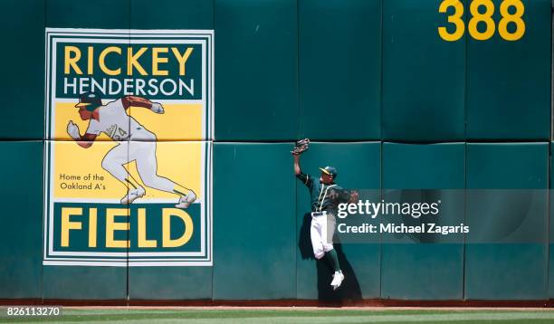 Jaycob Brugman of the Oakland Athletics makes a catch up against the wall during the game against the Cleveland Indians at the Oakland Alameda...