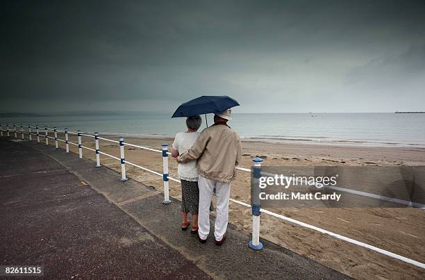 Couple look out to sea at Weymouth seafront on August 31 2008 in Weymouth, England. Forecasters have claimed that this August has been one of the...
