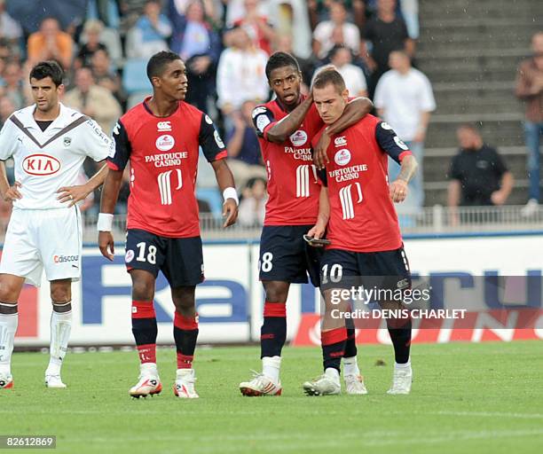 Lille's French midfielder Ludovic Obraniak is congratuled by his teammates, Brazilian midfielder Michel Bastos and French defender Franck Beria after...