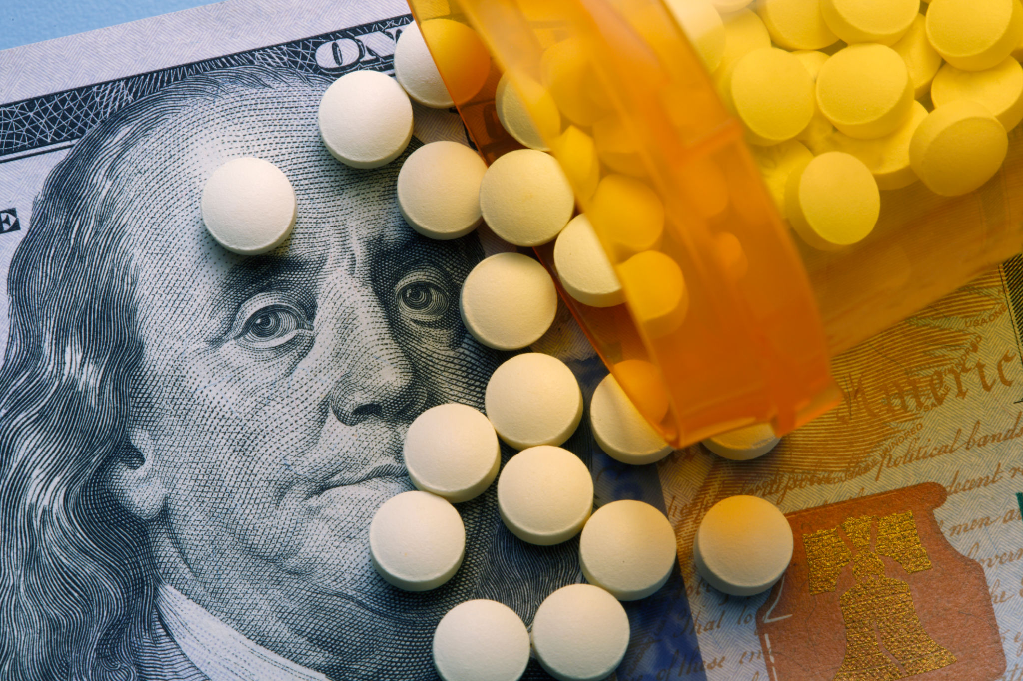 Pills Spill Out On To One Hundred Dollar Bill From Open Prescription Bottle Pills Spill Out On To One Hundred Dollar Bill From Open Prescription Bottle