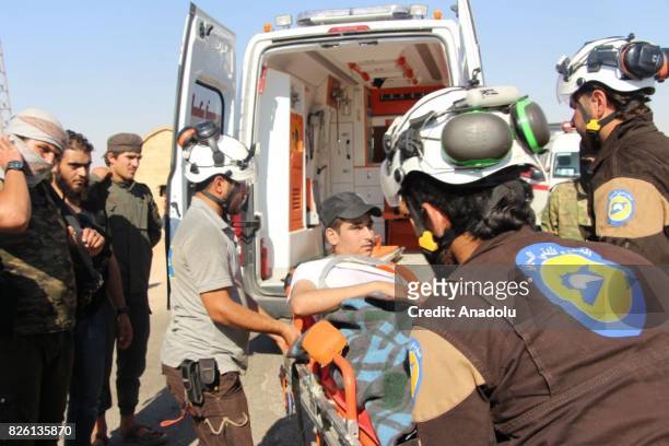 Medical staff help an injured man get off an ambulance, after a cease-fire announced between Hezbollah and Ahrar al-Sham, in Idlib, Syria on August...