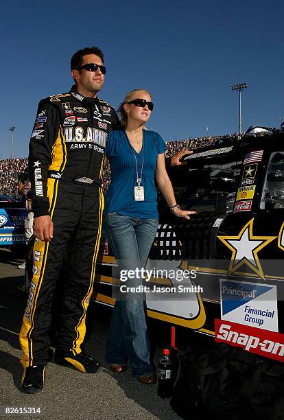 Aric Almirola, driver of the U.S. ARMY Chevrolet, and guest Janice Goss, stand on the grid during the national anthem for the NASCAR Sprint Cup...