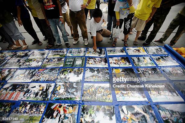 Anti Government People's Alliance for Democracy look at the pictures that show the confrontation outside Government House on September 1 in Bangkok,...