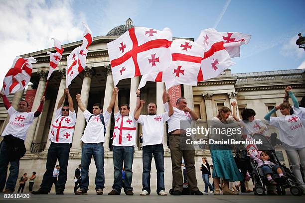 Georgians hold up their country's flag as they gather to voice their opinions during an anti-Russian protest at Trafalgar Square on September 1, 2008...