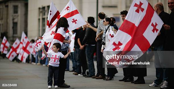 Georgians hold up their country's flag as they gather to voice their opinions during an anti-Russian protest at Trafalgar Square on September 1, 2008...