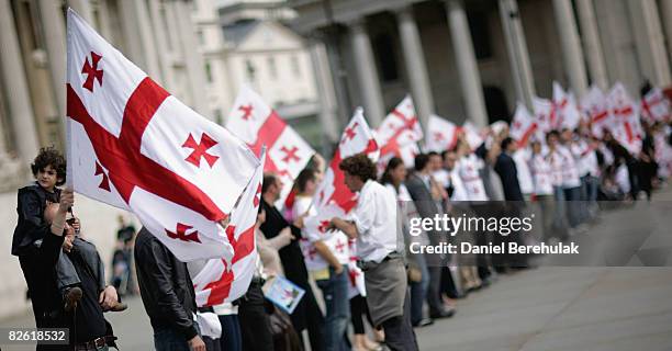 Georgians hold up their country's flag as they gather to voice their opinions during an anti-Russian protest at Trafalgar Square on September 1, 2008...