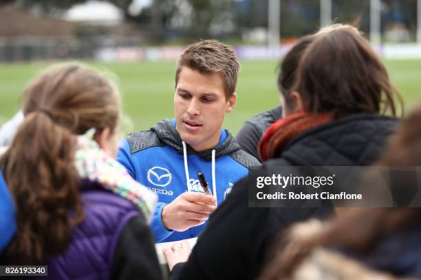 Andrew Swallow of the Kangaroos signs autographs during a North Melbourne Kangaroos AFL training session at Arden Street Ground on August 4, 2017 in...