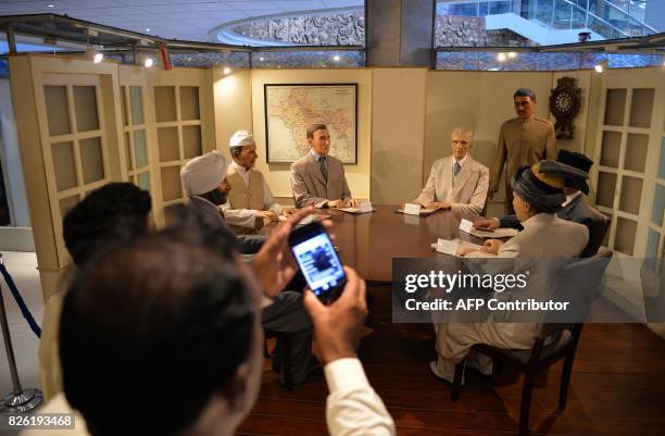 In this photograph taken on July 19 Pakistani visitors look at the statues of Pakistan's founder Muhammad Ali Jinnah , British viceroy Lord...