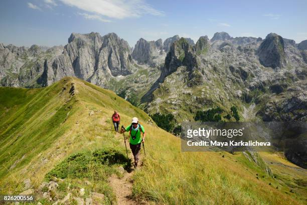tourists walking up a ridge in prokletije mountain, montenegro - montenegro photos et images de collection