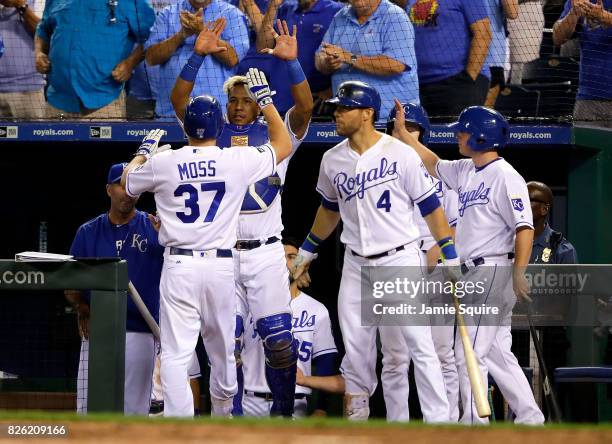 Brandon Moss of the Kansas City Royals is congratulaed by Salvador Perez after hitting a home run during the 8th inning of the game against the...