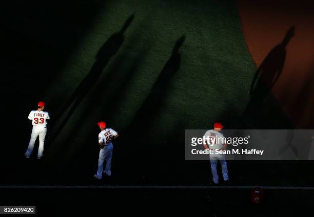 Ramon Flores, Ben Revere, and Mike Trout of the Los Angeles Angels of Anaheim look on prior to a game against the Philadelphia Phillies at Angel...