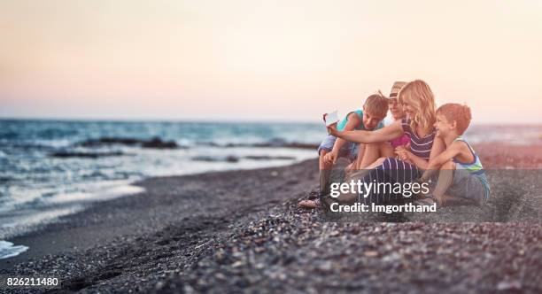 family taking selfie on a beach in the evening - the end stock pictures, royalty-free photos & images
