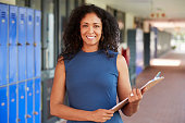 Middle aged black female teacher smiling in school corridor