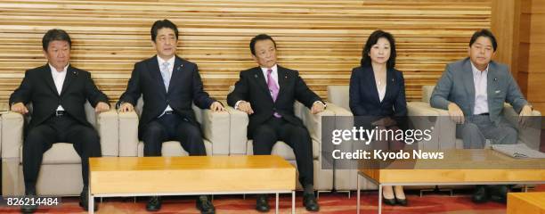 Japanese Prime Minister Shinzo Abe meets his ministers in his office in Tokyo on Aug. 4 a day after he reshuffled his Cabinet. Shown in the photo are...